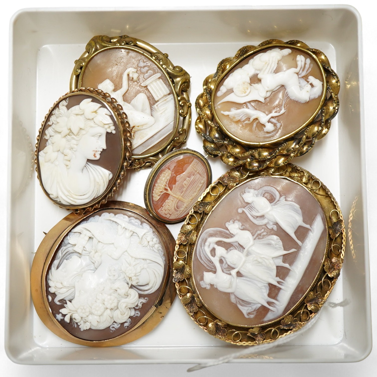 Six assorted Victorian and later yellow or white metal mounted oval cameo shells, one frame stamped 9ct, largest 64mm.